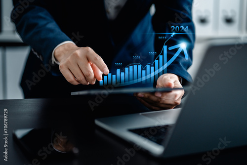 Fototapeta Naklejka Na Ścianę i Meble -  Businesswomen analyze the stock market with a digital candlestick chart and virtual bar chart,  market rise business market growth 2024, trend line increase profits, investments and financial concepts