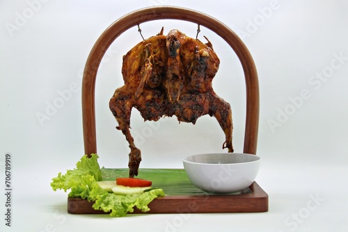 Bakakak Hayam or Ayam Bekakak or Grilled Whole Chicken with seasonings plus soy sauce, a dish from West Java and Jakarta, Indonesia. Usually served to brides at weddings. photo
