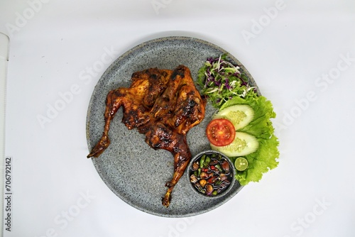 Bakakak Hayam or Ayam Bekakak or Grilled Whole Chicken with seasonings plus soy sauce, a dish from West Java and Jakarta, Indonesia. Usually served to brides at weddings. photo