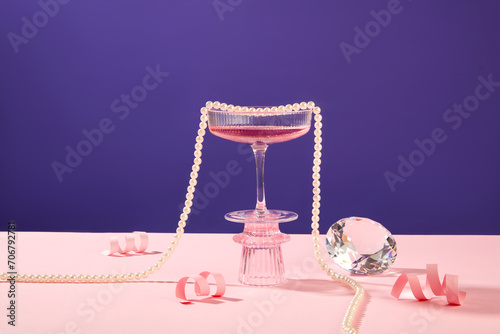 Canvas Print A glass of pink wine standing on a podium displayed with pink paper fireworks, a luxury diamond and a pearl necklace