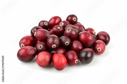A pile of cranberries is shown on a white surface, near a cranberry statue.