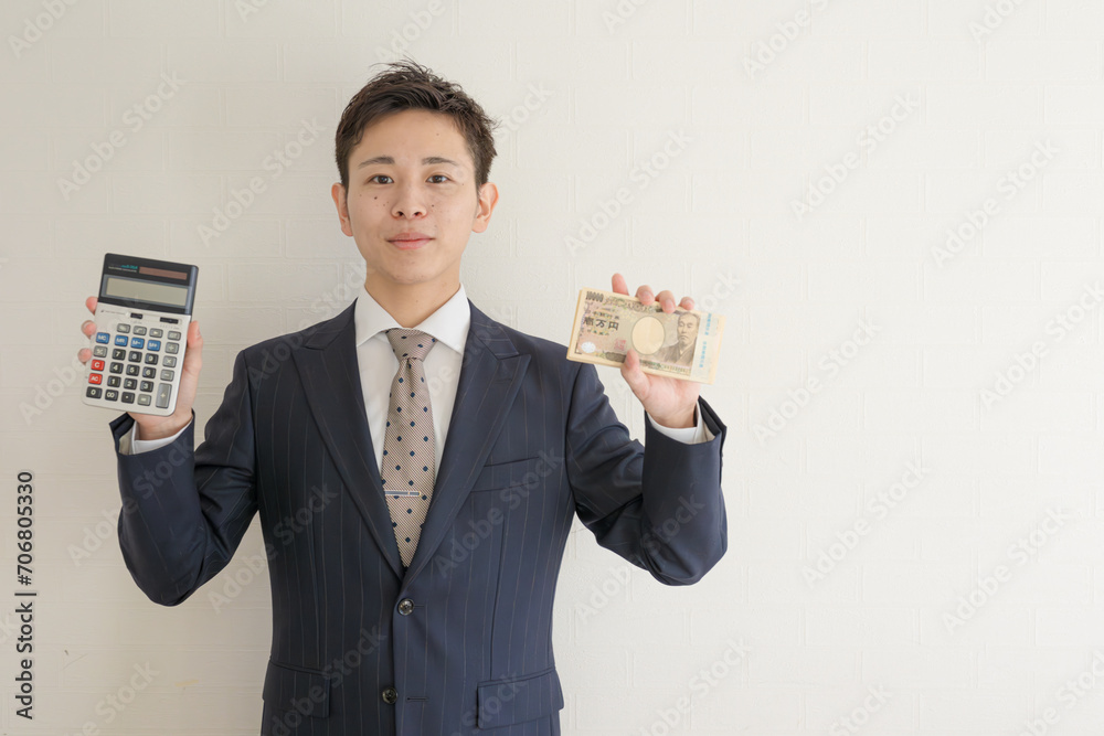 電卓と札束とスーツの男性