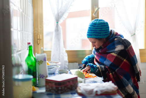 Mid Adult Female Unemployed Preparing herself a Poor Vegetable Meal in an Old Cold Apartment - Poverty Social Issues