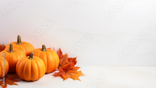 Fall background with orange pumpkins and fall leaves on a light surface 
