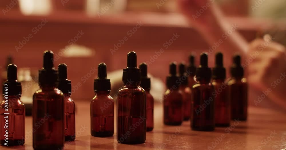 Crop craftsman mixing oils while making handmade perfume Crop craftsman mixing oils while making handmade perfume