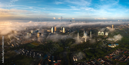 Aerial view the blue mosque of Shah Alam during early morning in low clouds with blue sky