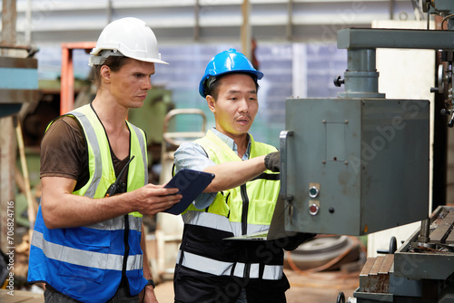 workers or technicians checking and control lathe machine in factory