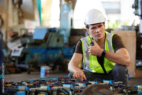 engineer or worker talking on walkie talkie and fixing machine in the factory photo