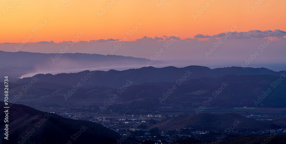 View from mountain top of beach, ocean, valley below at sunset, sunrise
