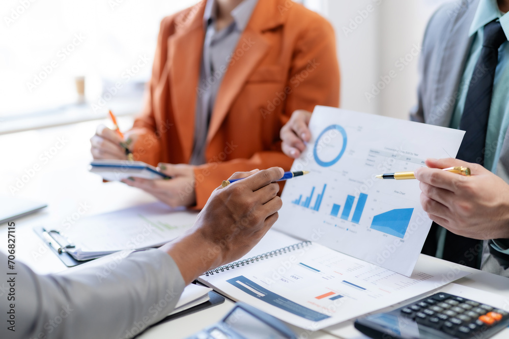 Meeting of business people pointing at graph. Group of businesspeople discussing together at a meeting. Meeting of business people pointing at graph. Group of businesspeople discussing together at a meeting.