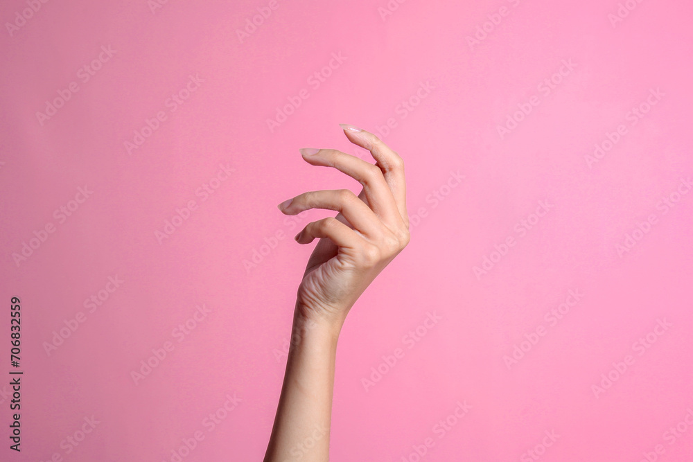 Woman hand gesture isolated on a pink studio background