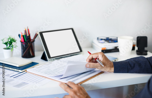 Lawyer or legal advisor holding pen reading and carefully checking the validity of documents and contract agreements for signing contracts and use tablet computer to contact customers online