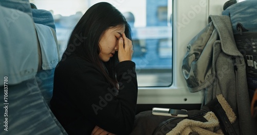 Train, tired and woman in city for travel, commute and journey on metro transportation in town. Passenger, railway and person with headache, frustrated and exhausted on trip in public transport photo