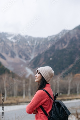 Alone in nature's embrace, Asian woman in a pink fleece. Climbing, standing by the lake, and exploring the scenic beauty of Japan's breathtaking destination. © Jirawatfoto