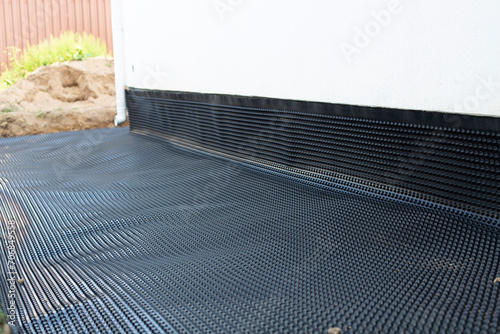 Waterproofing membrane for the blind area of a private house. Construction of a country house. Drainage of water from the foundation of the house.