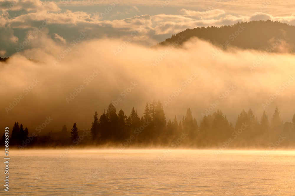 Fototapeta premium Atmospheric morning fog over Lake Yazevoe in eastern Kazakhstan. Lake Yazevoe is located at an altitude of 1685 meters above sea level. It is part of the State National Natural Park 
