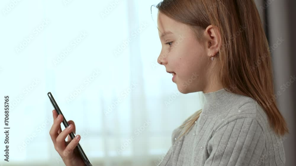 Happy girl holding mobile phone, side view Happy girl holding mobile phone, side view
