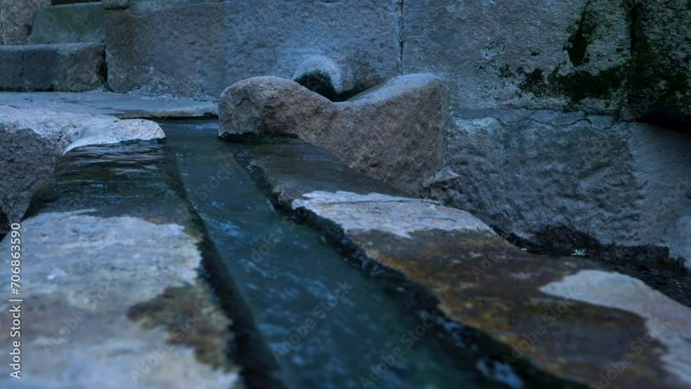 Boiling hot water pours along open shallow granite rock trench in Ourense Spain Boiling hot water pours along open shallow granite rock trench in Ourense Spain
