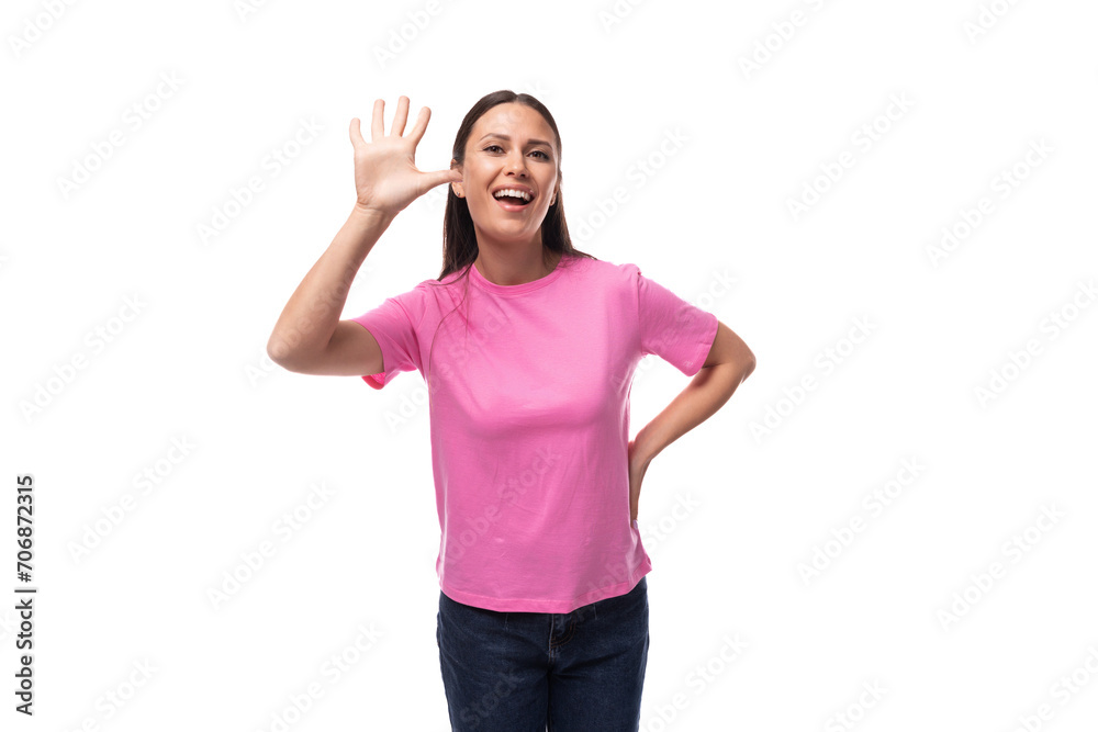 young slim european woman with black straight hair is dressed in a pink t-shirt on a studio background with copy space young slim european woman with black straight hair is dressed in a pink t-shirt on a studio background with copy space