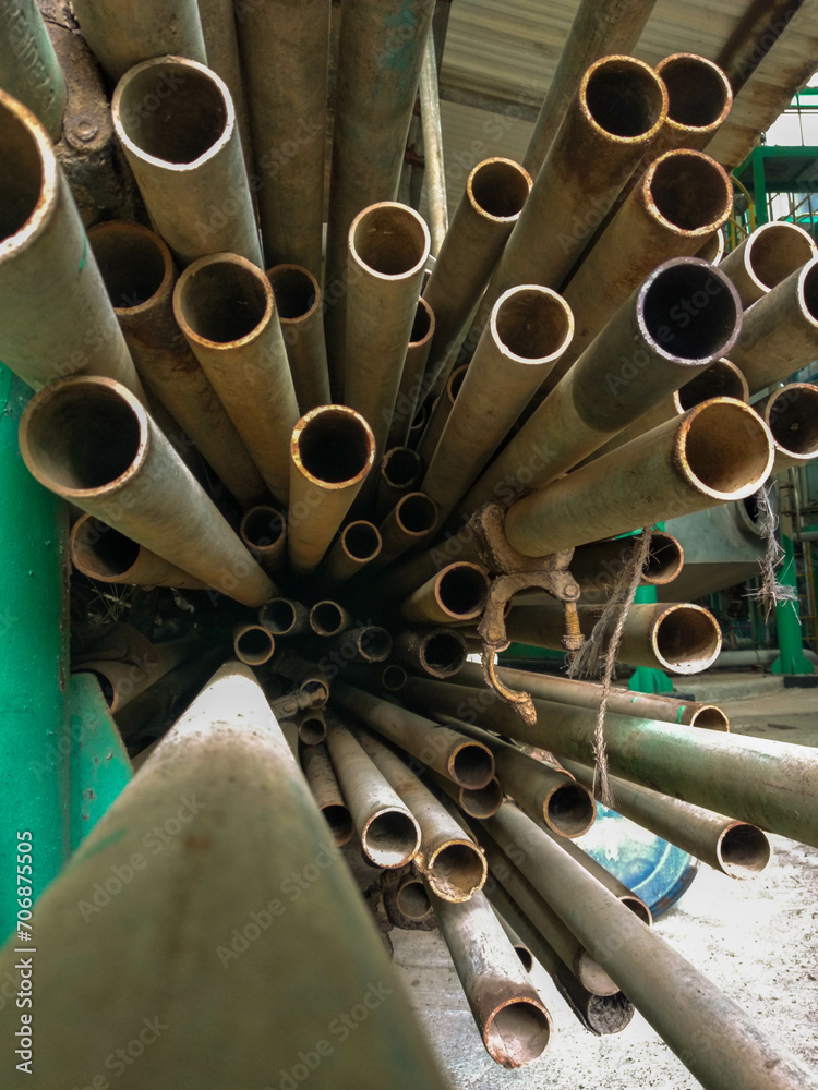 pile of used scaffolding poles stored in an old factory warehouse