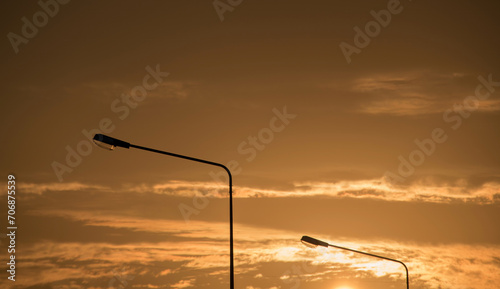 Traffic lamp pole silhouette with sunrise sky in background