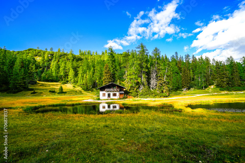 Krallersee on the high plateau of the Tauplitzalm with a small hut. View of the lake at the Totes Gebirge in Styria. Idyllic landscape with green nature and a lake on the Tauplitz. 