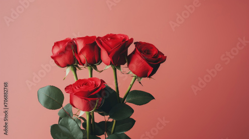 A lush bouquet of vibrant red roses presented against a soft pink background  symbolizing love and passion.