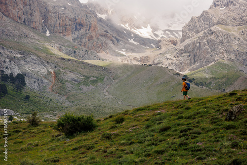 boy goes with a backpack on the background of the mountains. child traveler with backpack, travel, lifestyle concept