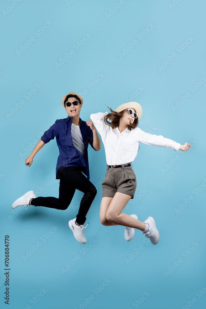 Asian couple jumping for joy isolated on blue background. Asian couple jumping for joy isolated on blue background.