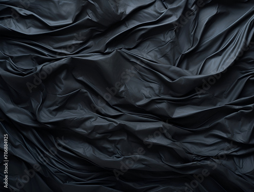 Black crumpled paper abstract texture in low light background