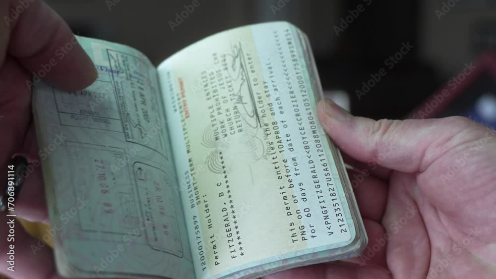 Man hold his US Passport full of foreign travel visas - flipping through pages