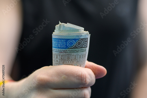 Pieniądze zwinięte w rulon,  dużo polskich banknotów pln w dłoni  photo