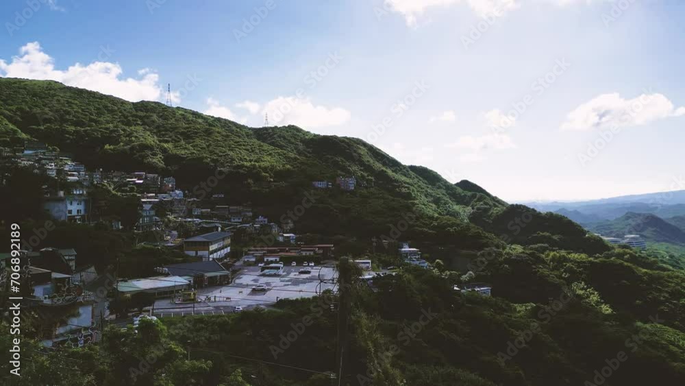 Slow drone movement over the small town of Jiufen in Taiwan. Cinematic panorami view over mountains in Taiwan with sea in background. Cloudy sky over tropical mountains. Travel in Taiwan. Slow drone movement over the small town of Jiufen in Taiwan. Cinematic panorami view over mountains in Taiwan with sea in background. Cloudy sky over tropical mountains. Travel in Taiwan.