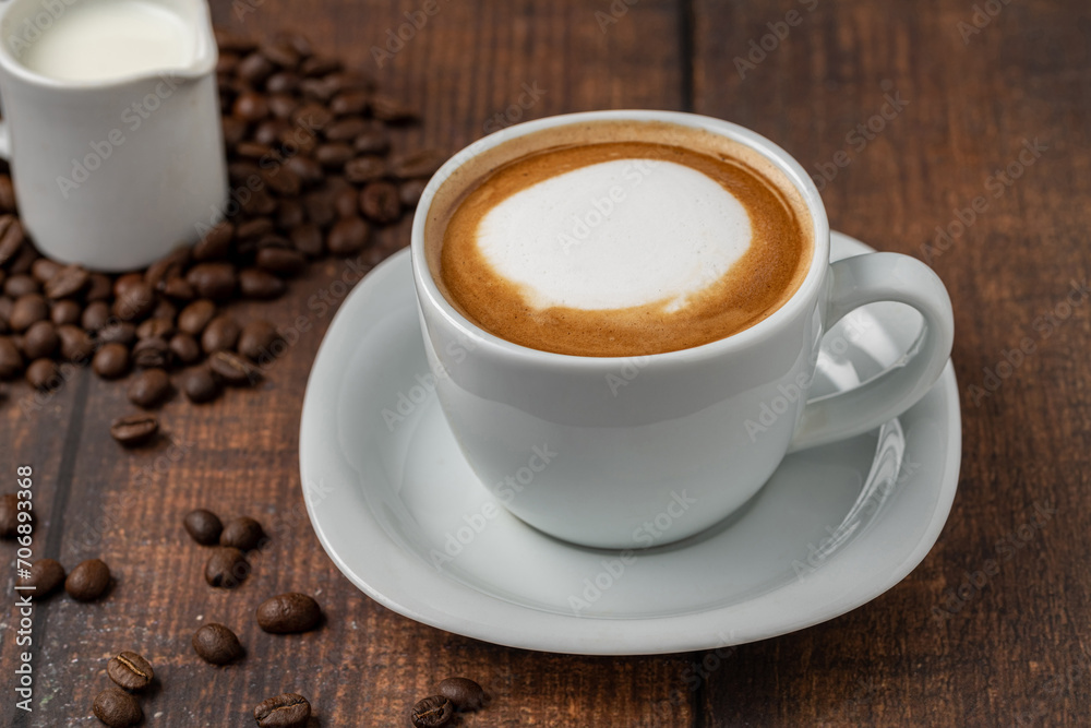 Relaxing latte coffee in white porcelain cup on wooden table Relaxing latte coffee in white porcelain cup on wooden table