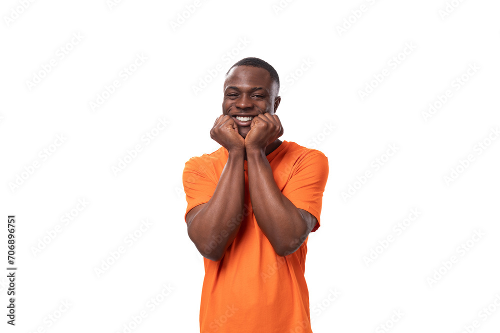 young successful handsome african man dressed in orange t-shirt on studio white background young successful handsome african man dressed in orange t-shirt on studio white background
