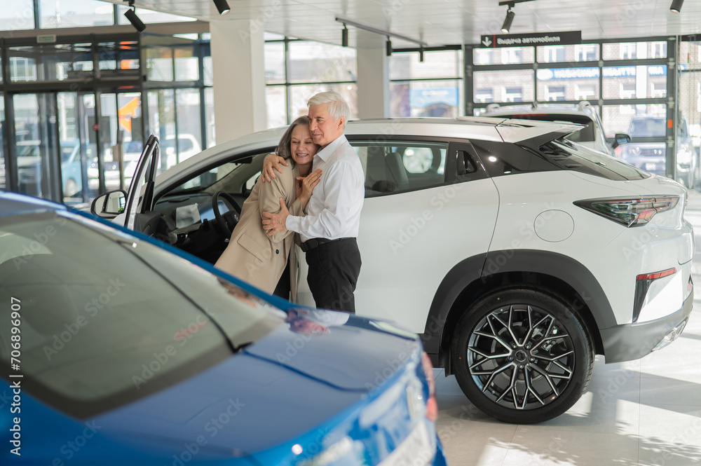 Mature Caucasian couple hugging with happiness while buying a new car. Mature Caucasian couple hugging with happiness while buying a new car.