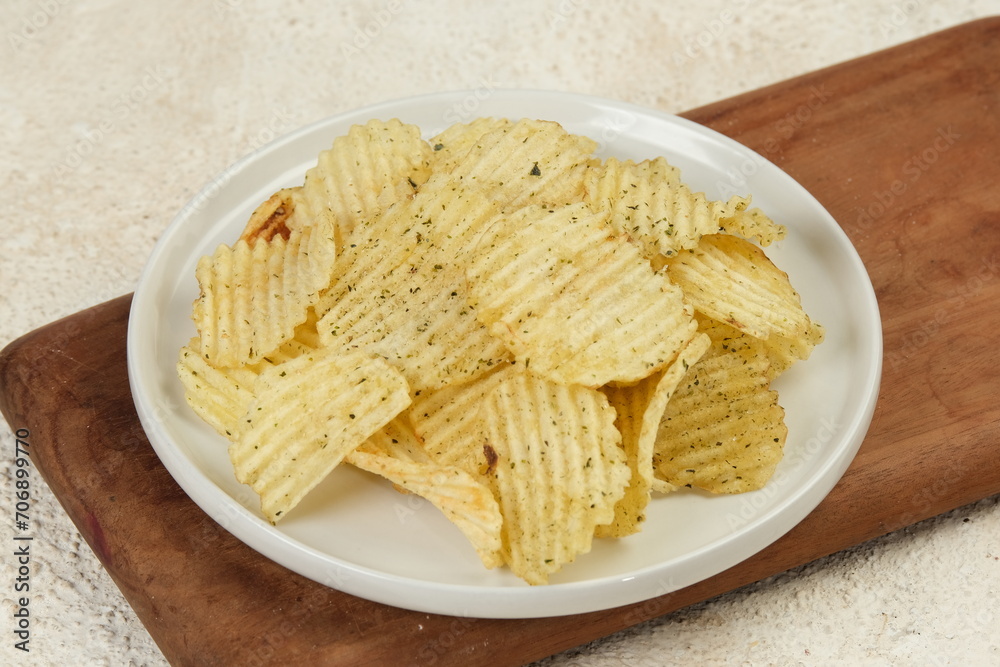 crispy ridged potato chips on white plate,white background crispy ridged potato chips on white plate,white background