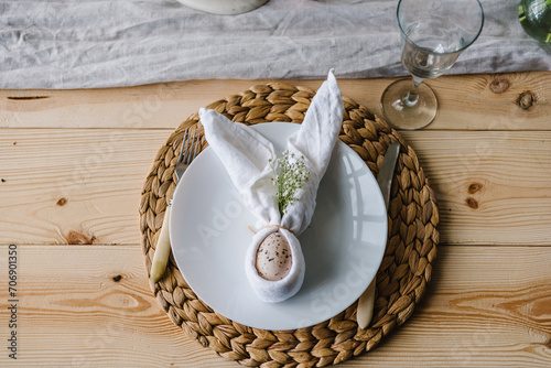 Canvas Print Setting table for Easter dinner with ceramic plates with bunny made of linen napkin and easter egg