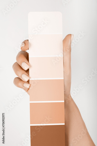 Hand holding Color samples palette design catalog. New trending PANTONE Peach Fuzz colour of 2024 year (ID: 706902971)