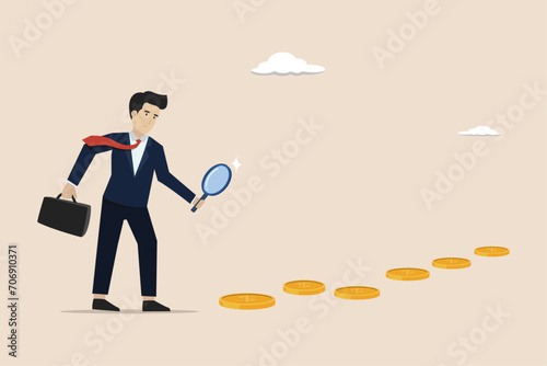 Searching for investment opportunity and earning concept, financial success or salary raise, curios businessman with magnifier inspect and follow money coins trail.