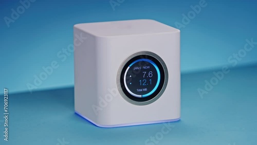 LCD display on high end wireless internet wifi router is counting total transferred kilobytes and megabytes as data is downloaded through network. Cinematic hiqh quality product shot, blue background. photo