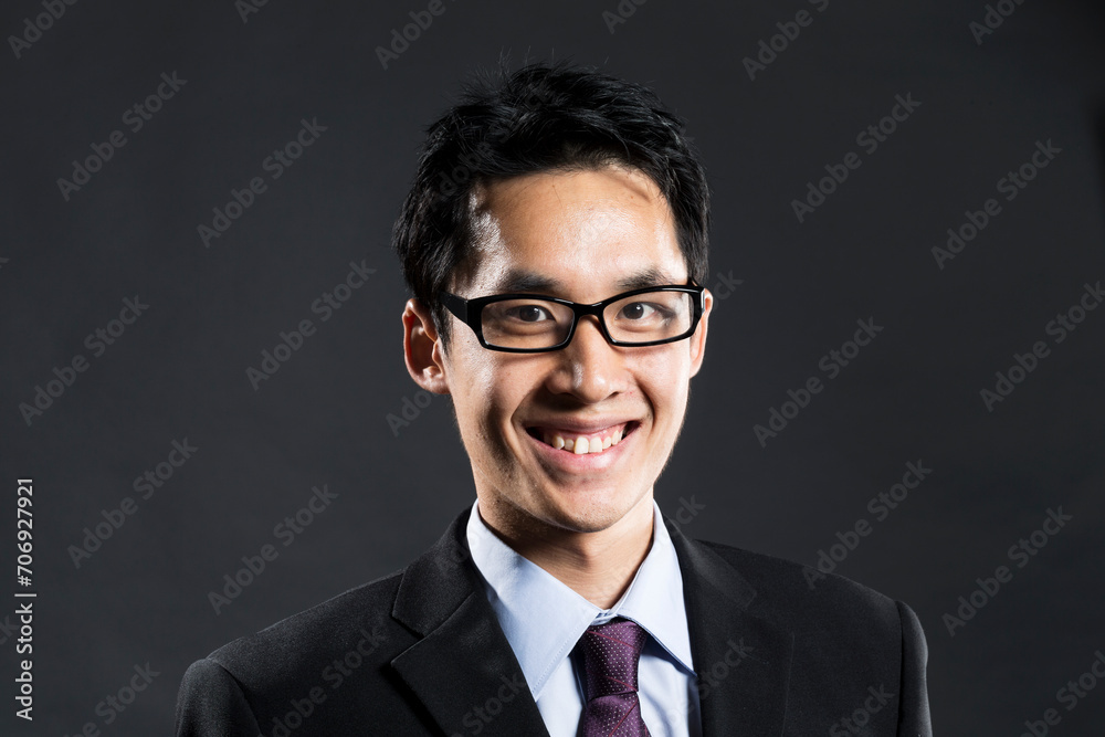 Stylish Chinese business man. In front of dark background Stylish Chinese business man. In front of dark background