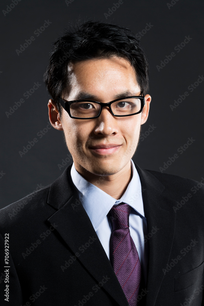 Stylish Chinese business man. In front of dark background Stylish Chinese business man. In front of dark background