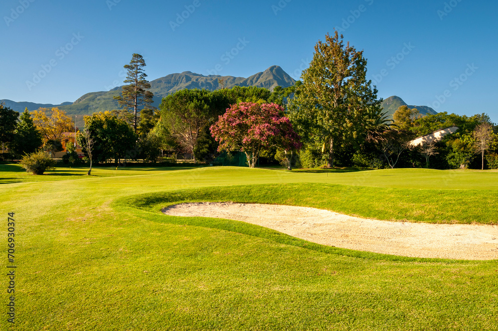Golf course with treelined fairways and mountain views