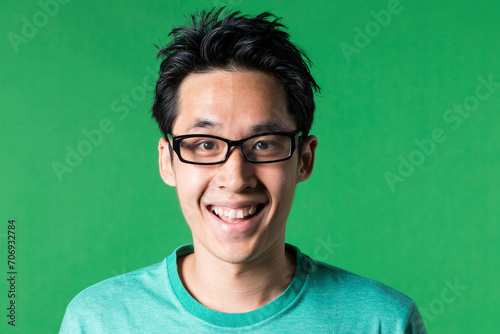 Portrait of an excited Asian man. Green background photo