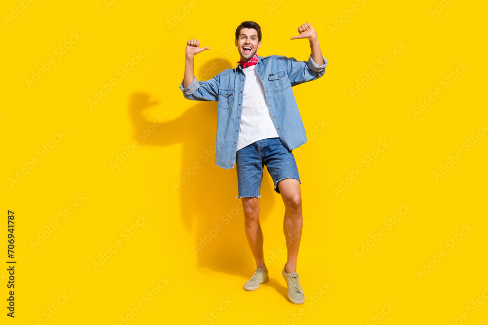 Full body photo of optimistic man dressed denim shirt indicating at himself near empty space isolated on vivid yellow color background Full body photo of optimistic man dressed denim shirt indicating at himself near empty space isolated on vivid yellow color background