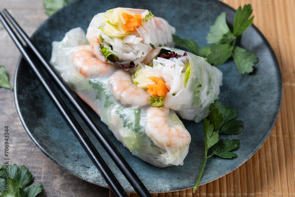 Vietnamese spring rolls with vegetables, rice noodles and prawns on wooden table. Close up Vietnamese spring rolls with vegetables, rice noodles and prawns on wooden table. Close up