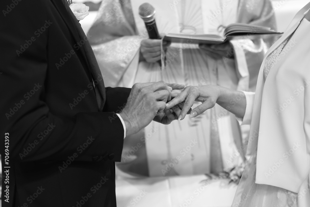 The groom carefully puts the wedding ring on the bride's finger. the wedding ceremony, ring wedding