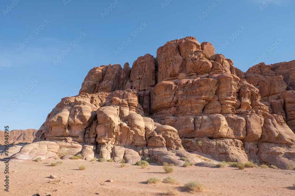 A breathtaking, large rock formation emerges from the sandy expanse of the Wadi Rum desert in Jordan. A breathtaking, large rock formation emerges from the sandy expanse of the Wadi Rum desert in Jordan.