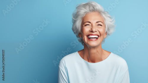 Joyful Senior Woman Laughing Heartily Against Blue Background